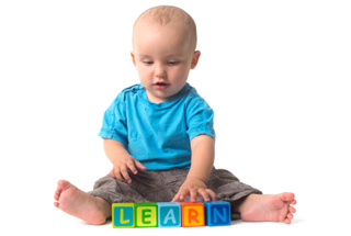 Baby playing with blocks that spell LEARN